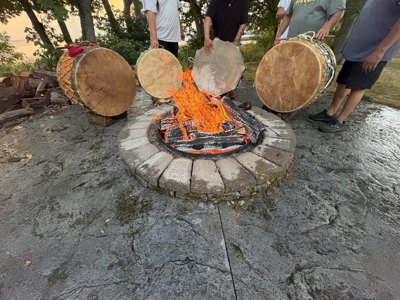 Four hand-laced drums standing close to the flames to warm